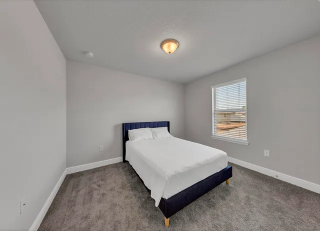 a bedroom with a bed and a window