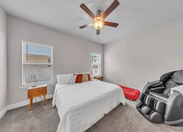 a bedroom with a bed dresser and a chandelier