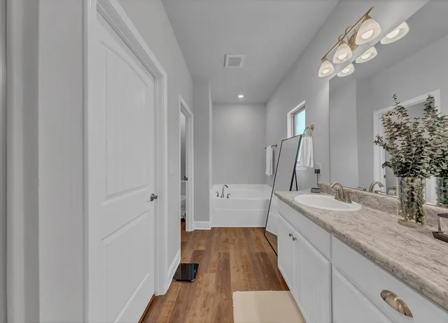 a spacious bathroom with a double vanity sink a mirror and shower