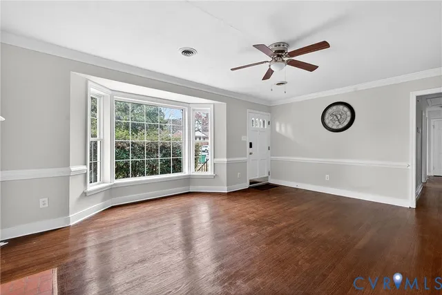 a kitchen with wooden floors white cabinets appliances and a window