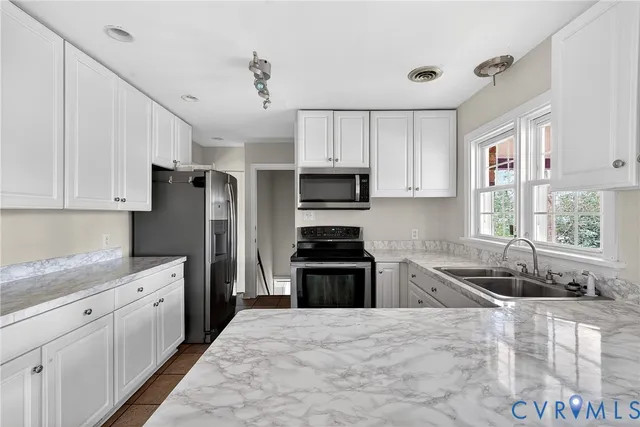 a kitchen with stainless steel appliances granite countertop a sink stove and cabinets