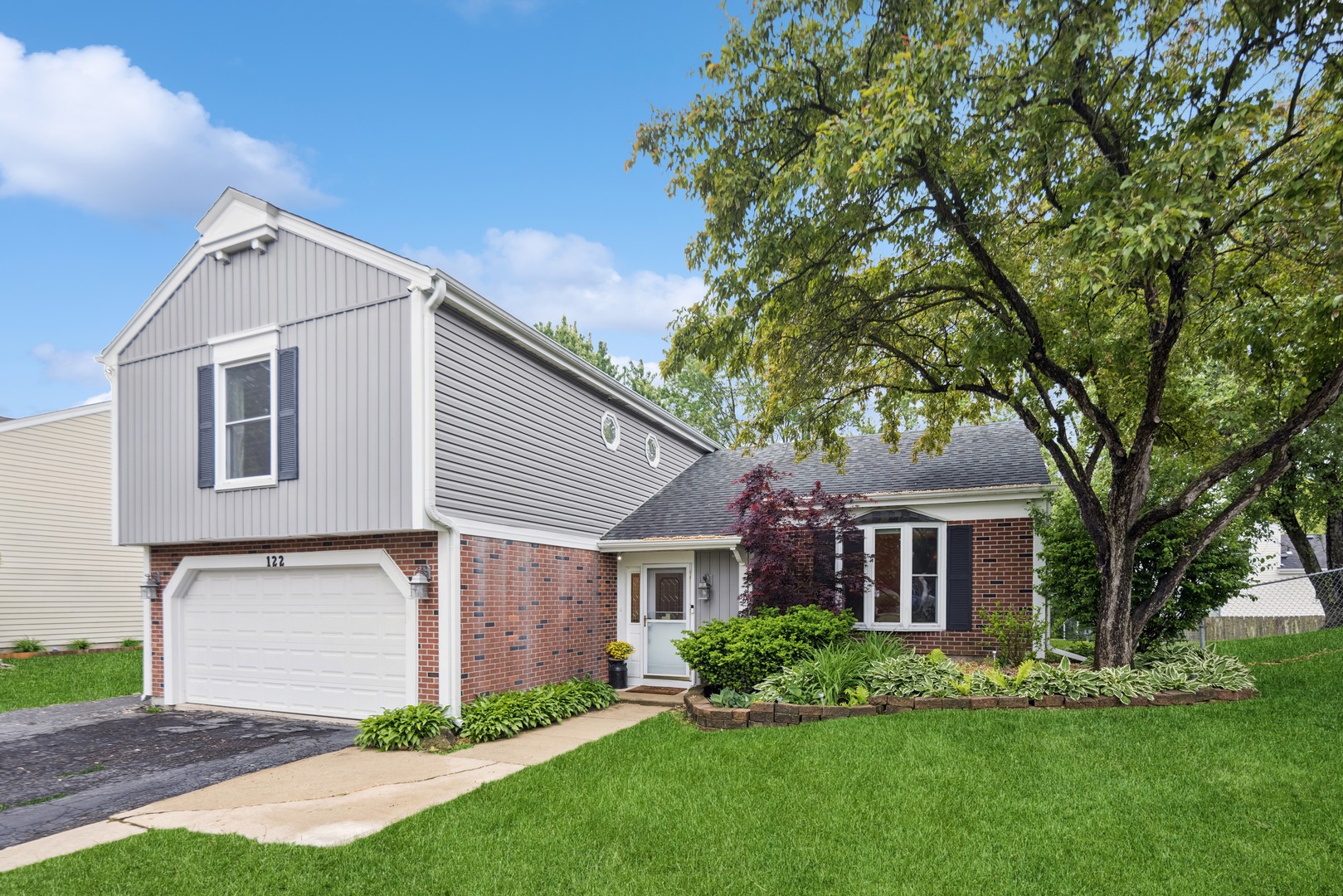 a front view of a house with a garden and yard