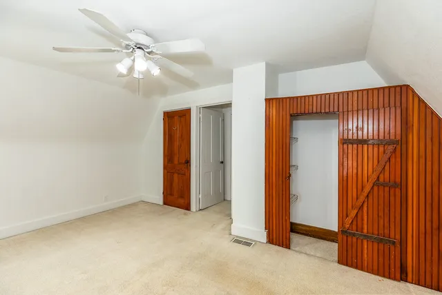 an empty room with fan and entrance