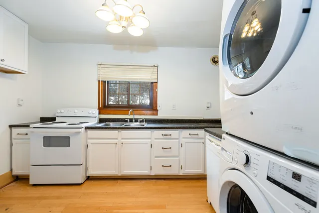 a utility room with granite countertop a sink a washer and dryer