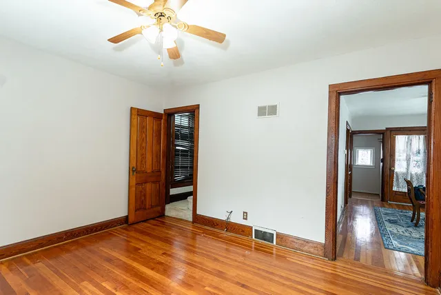 a view of an empty room with window and wooden floor