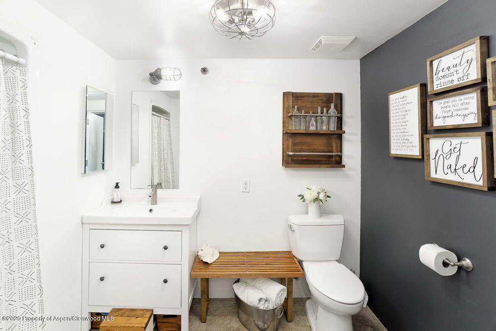 28 Widget Street, Unit 415 Basalt, CO 81621 - Photo 7 of 12 a bathroom with a toilet a sink a mirror and a window