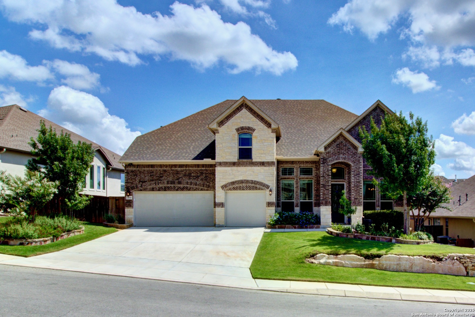 a front view of a house with a garden and trees