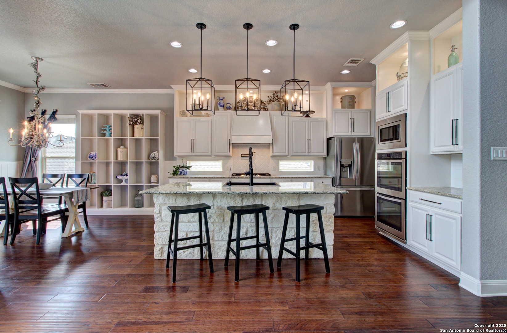 28518 Tristant Ridge San Antonio, TX 78260 - Photo 12 of 43 a kitchen with stainless steel appliances kitchen island granite countertop a table chairs and a refrigerator
