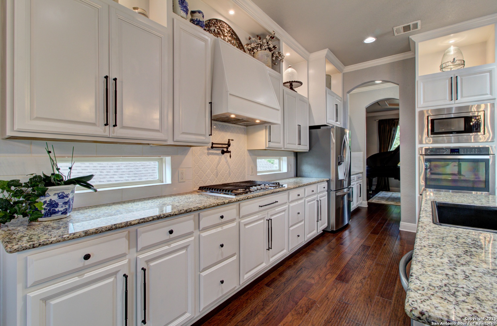 28518 Tristant Ridge San Antonio, TX 78260 - Photo 15 of 43 a large kitchen with stainless steel appliances granite countertop a lot of counter space and wooden floors