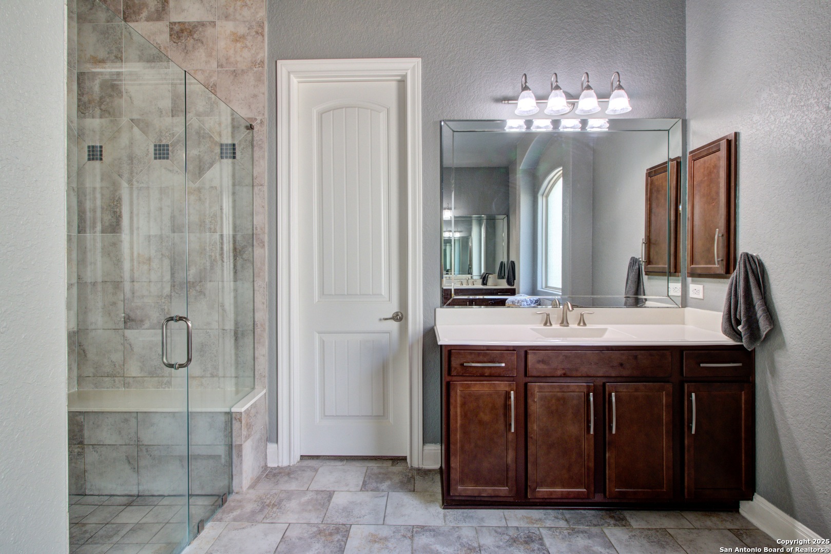 28518 Tristant Ridge San Antonio, TX 78260 - Photo 23 of 43 a spacious bathroom with a granite countertop sink a mirror and a shower