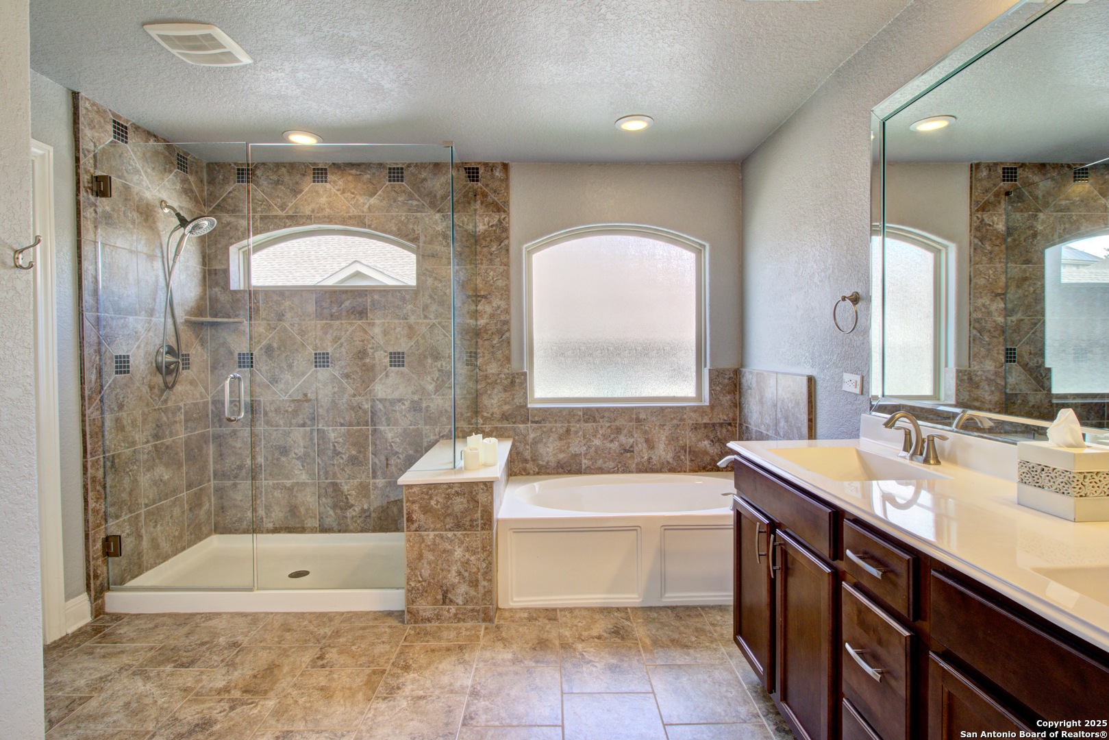 28518 Tristant Ridge San Antonio, TX 78260 - Photo 31 of 43 a spacious bathroom with a double vanity sink a large mirror and bathtub