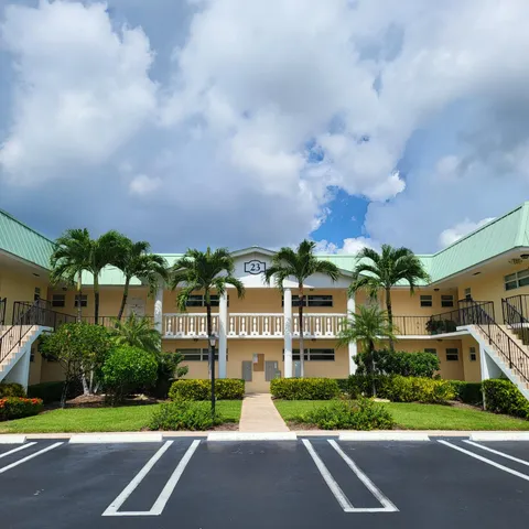 a front view of a house with a yard and car parked
