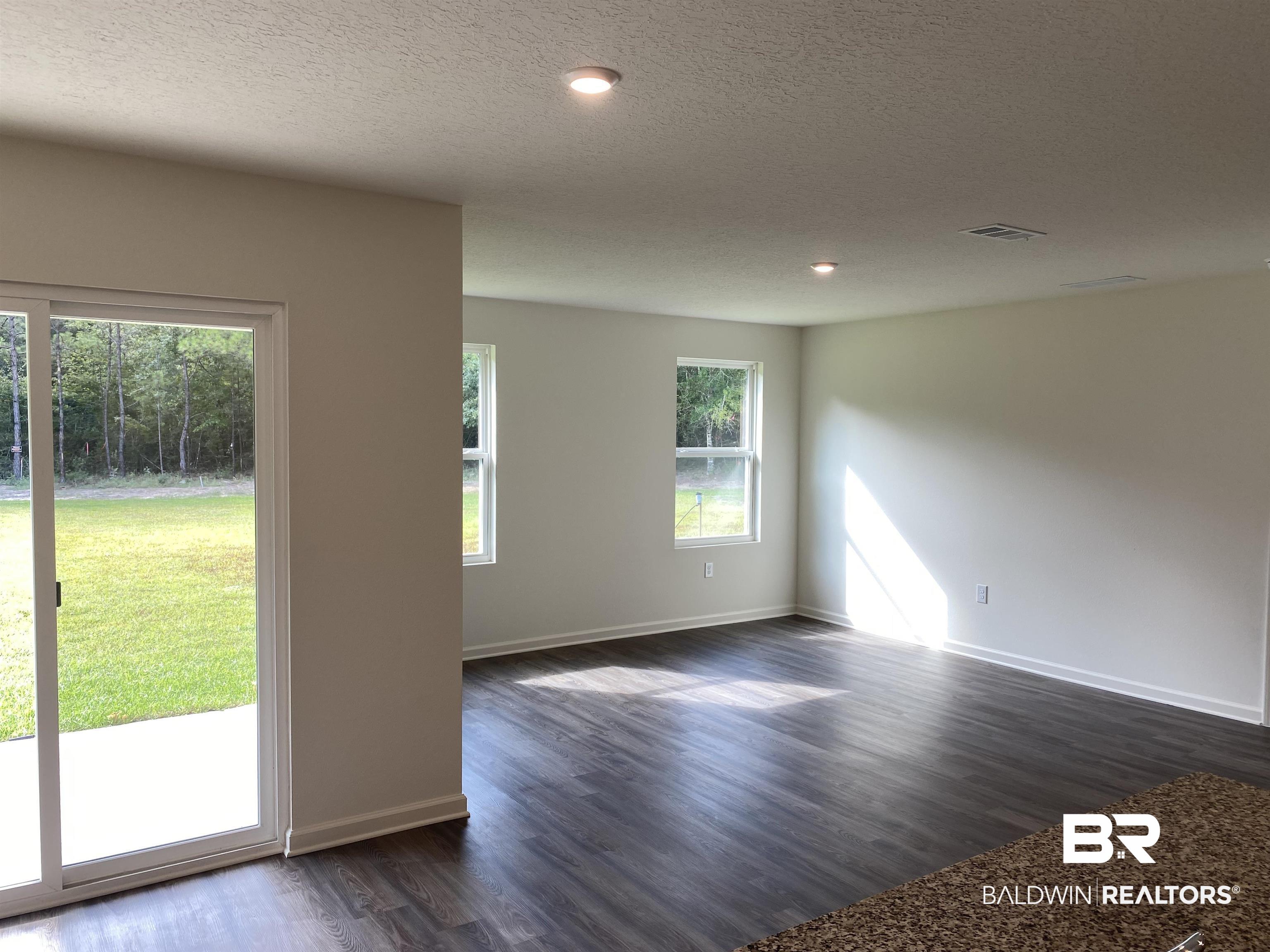 21641 Sutherland Circle Fairhope, AL 36532 - Photo 8 of 17 Unfurnished room featuring a textured ceiling and dark hardwood / wood-style floors