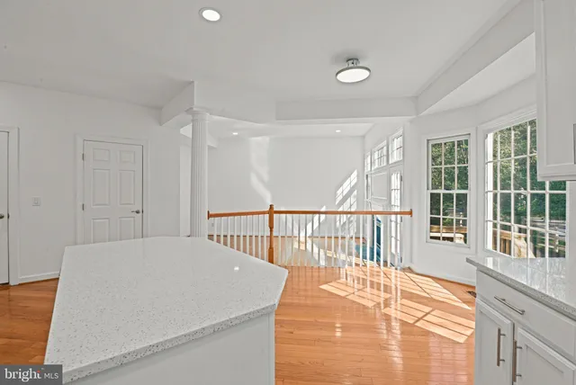 a view of a bedroom with wooden floor and windows