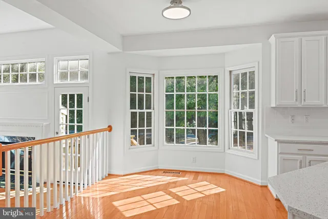 a view of a bedroom with wooden floor and windows