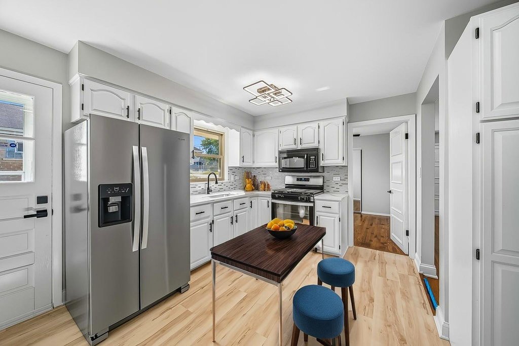 12549 South Tripp Avenue Alsip, IL 60803 - Photo 12 of 30 a kitchen with stainless steel appliances a refrigerator a stove a sink dishwasher a refrigerator with a dining table and chairs