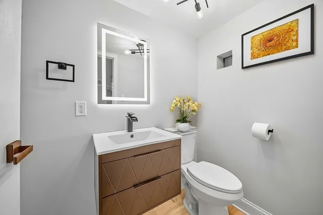 a bathroom with a toilet sink and mirror