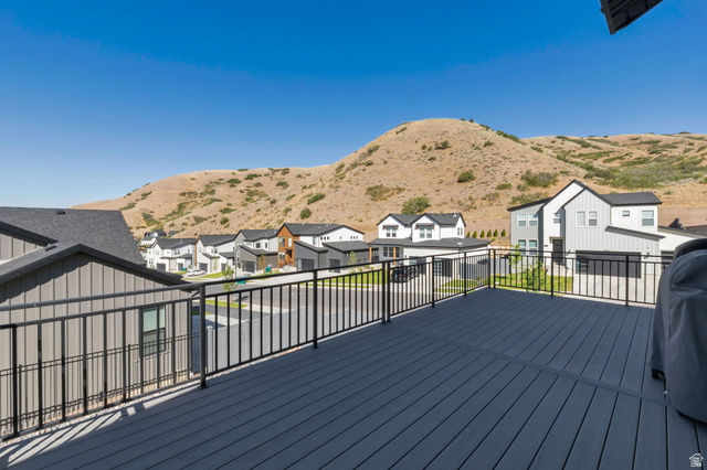 1711 West Canyon Rim Road North Lehi, UT 84048 - Photo 26 of 31 Spacious outdoor deck with composite decking and black metal railing, offering a clear outlook of the surrounding neighborhood and natural hillside