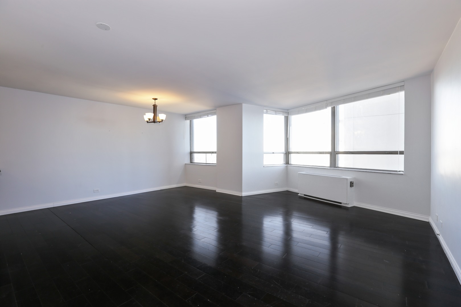 5701 North Sheridan Road, Unit 22H Chicago, IL 60660 - Photo 2 of 10 a view of an empty room with wooden floor and a window
