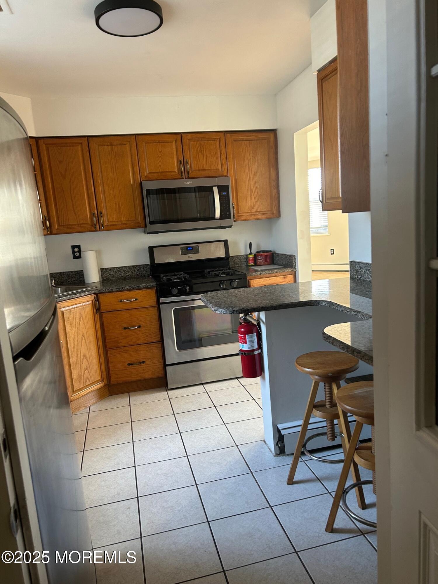 31 Main Street, Unit UPSTAIRS Englishtown, NJ 07726 - Photo 3 of 10 a kitchen with stainless steel appliances a stove a sink and a microwave
