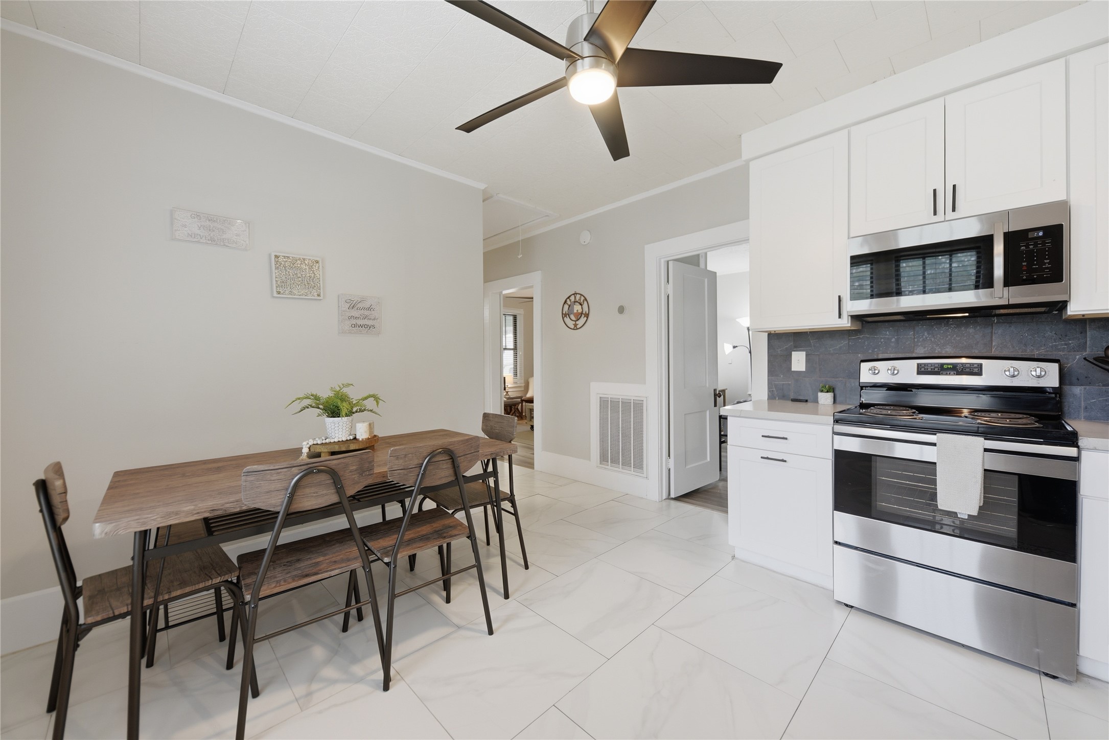 1500 Church Street Brenham, TX 77833 - Photo 10 of 30 a kitchen with stainless steel appliances kitchen island granite countertop a table chairs microwave and cabinets