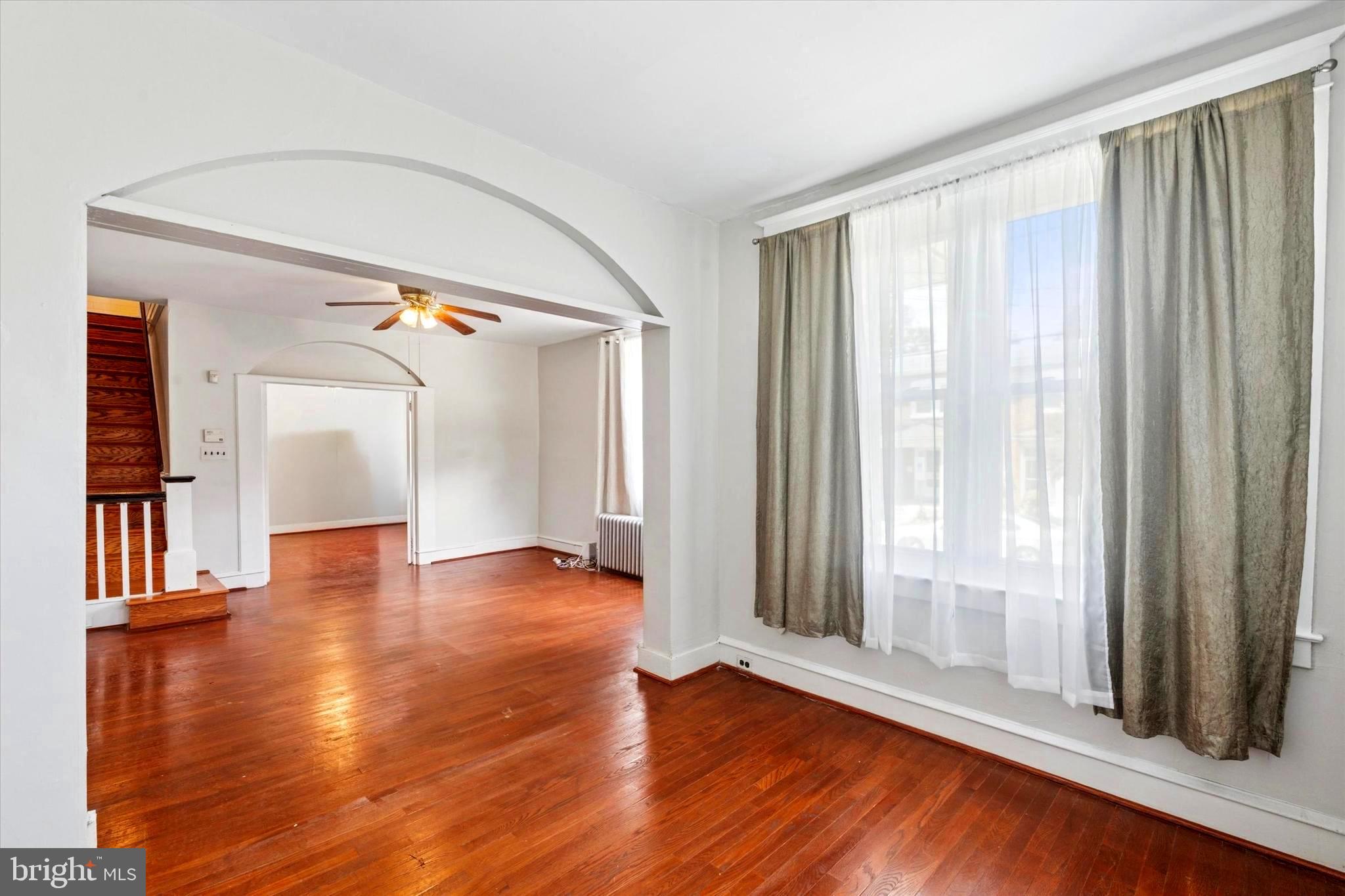 124 Arnold Road Ardmore, PA 19003 - Photo 12 of 24 an empty room with wooden floor and windows with curtains