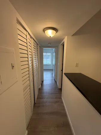 a view of a hallway with wooden floor and staircase