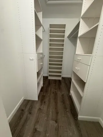 a view of an empty room with wooden floor and staircase