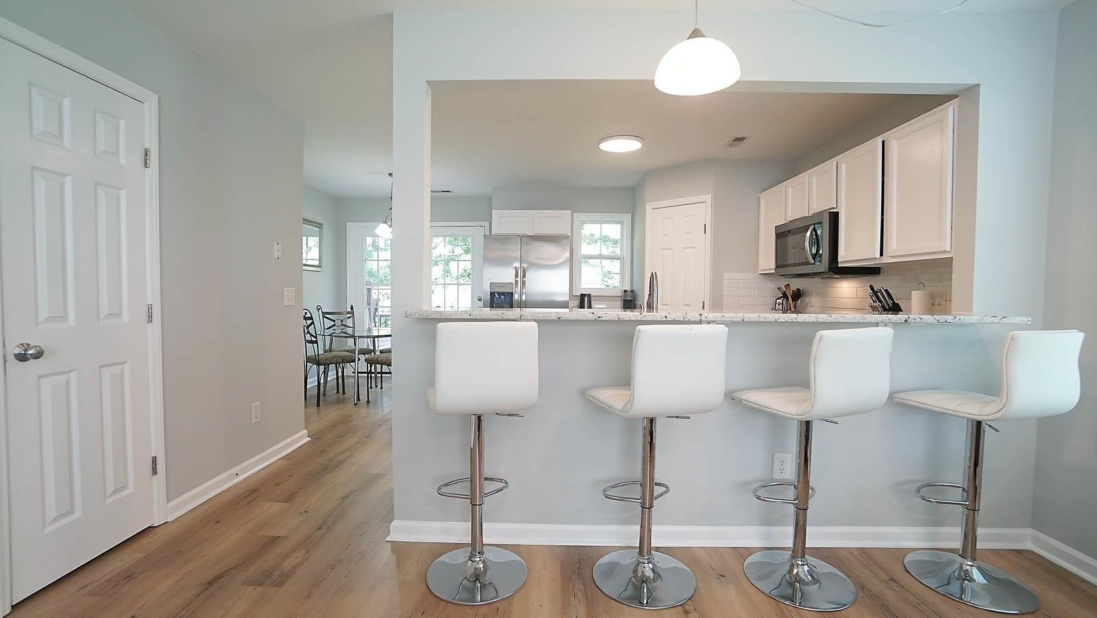 4305 Chimney Stone Road Durham, NC 27704 - Photo 3 of 21 a kitchen with stainless steel appliances a dining table chairs and sink