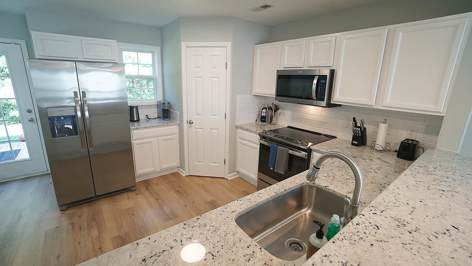 4305 Chimney Stone Road Durham, NC 27704 - Photo 5 of 21 a kitchen with stainless steel appliances granite countertop a refrigerator a stove top oven a sink and dishwasher