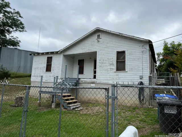 a backyard of a house with barbeque oven table and chairs