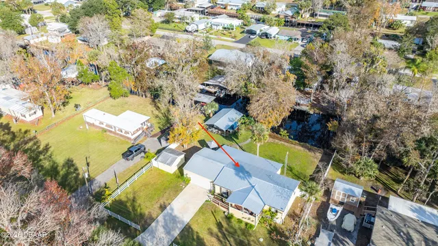 an aerial view of a swimming pool with outdoor seating and yard