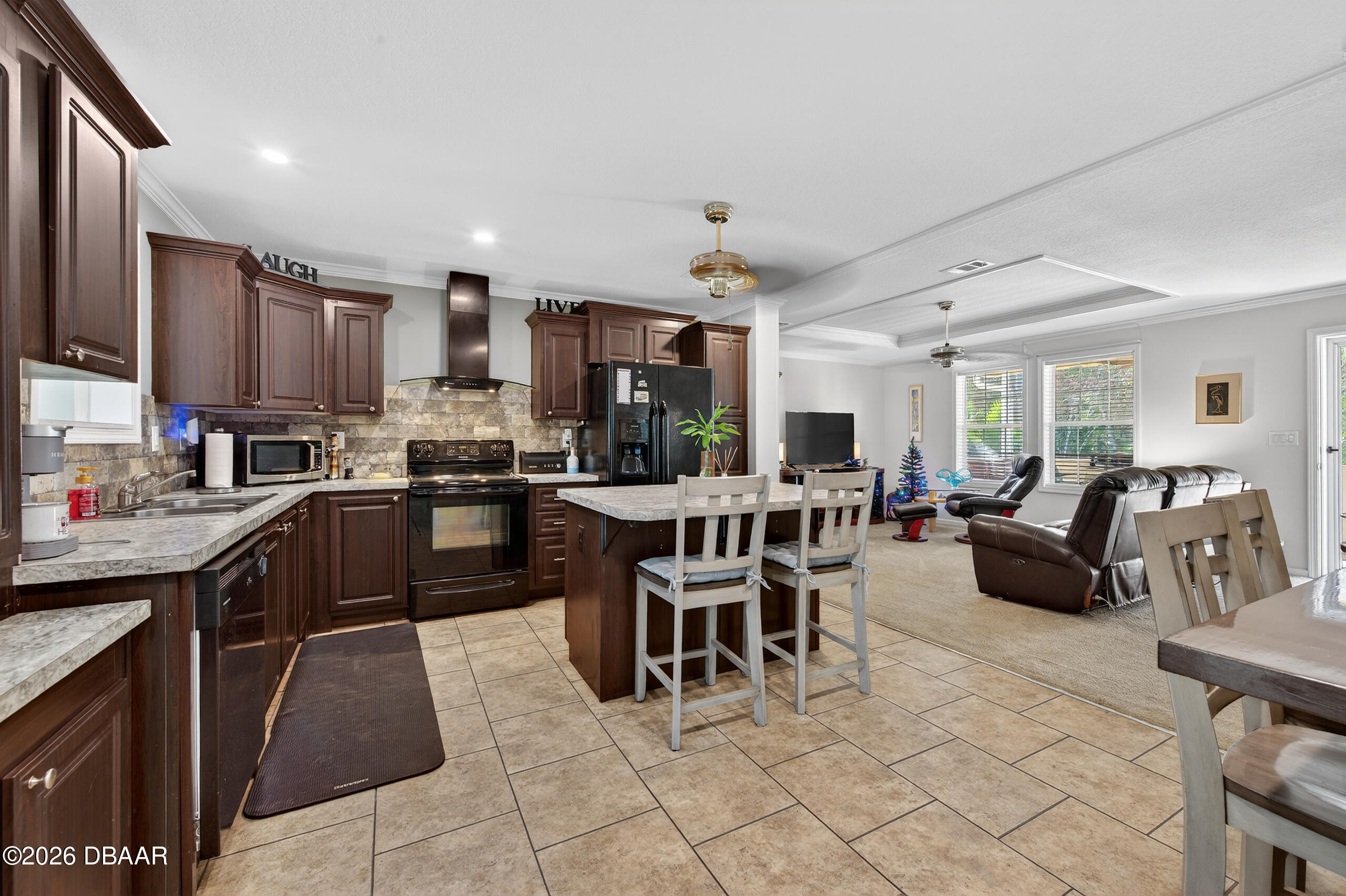 56320 Cherry Tree Road Astor, FL 32102 - Photo 9 of 39 a kitchen with stainless steel appliances kitchen island granite countertop a table chairs and a refrigerator