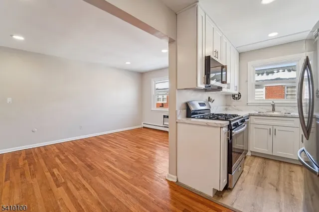 a kitchen with granite countertop wooden floors and white stainless steel appliances