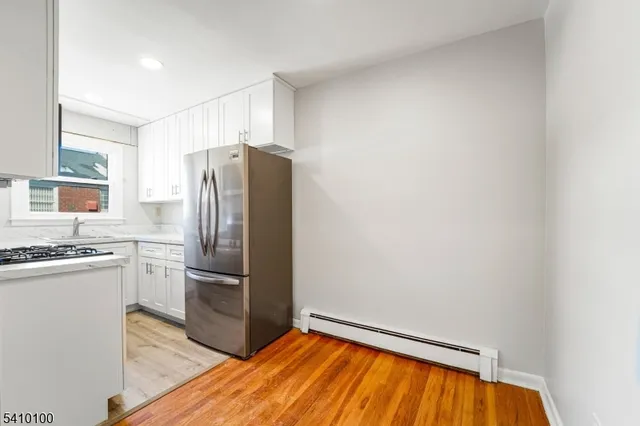 a kitchen with granite countertop a refrigerator and a stove top oven