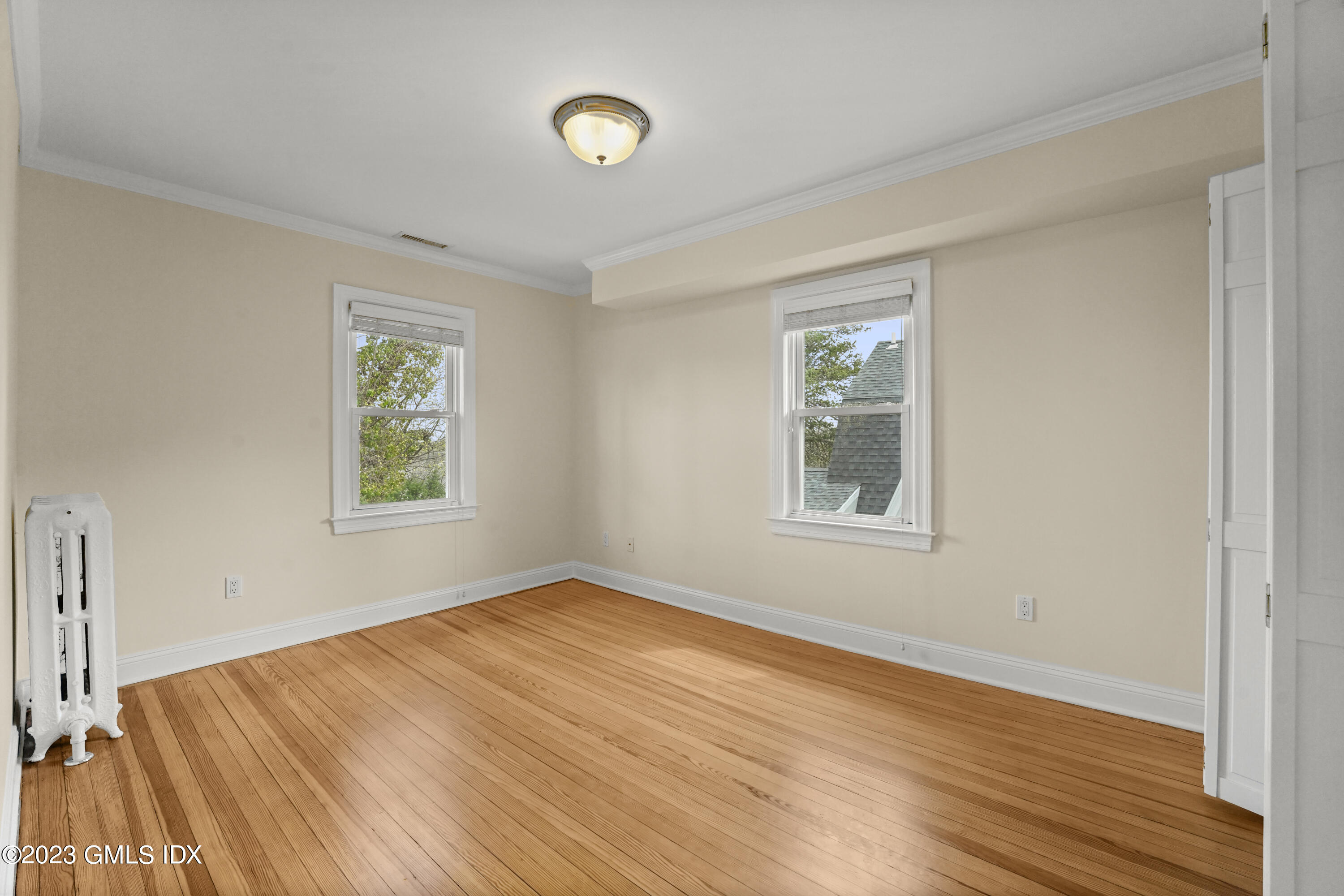 59 Ridge Street, Unit 2 Greenwich, CT 06830 - Photo 16 of 31 a view of an empty room with wooden floor and a window