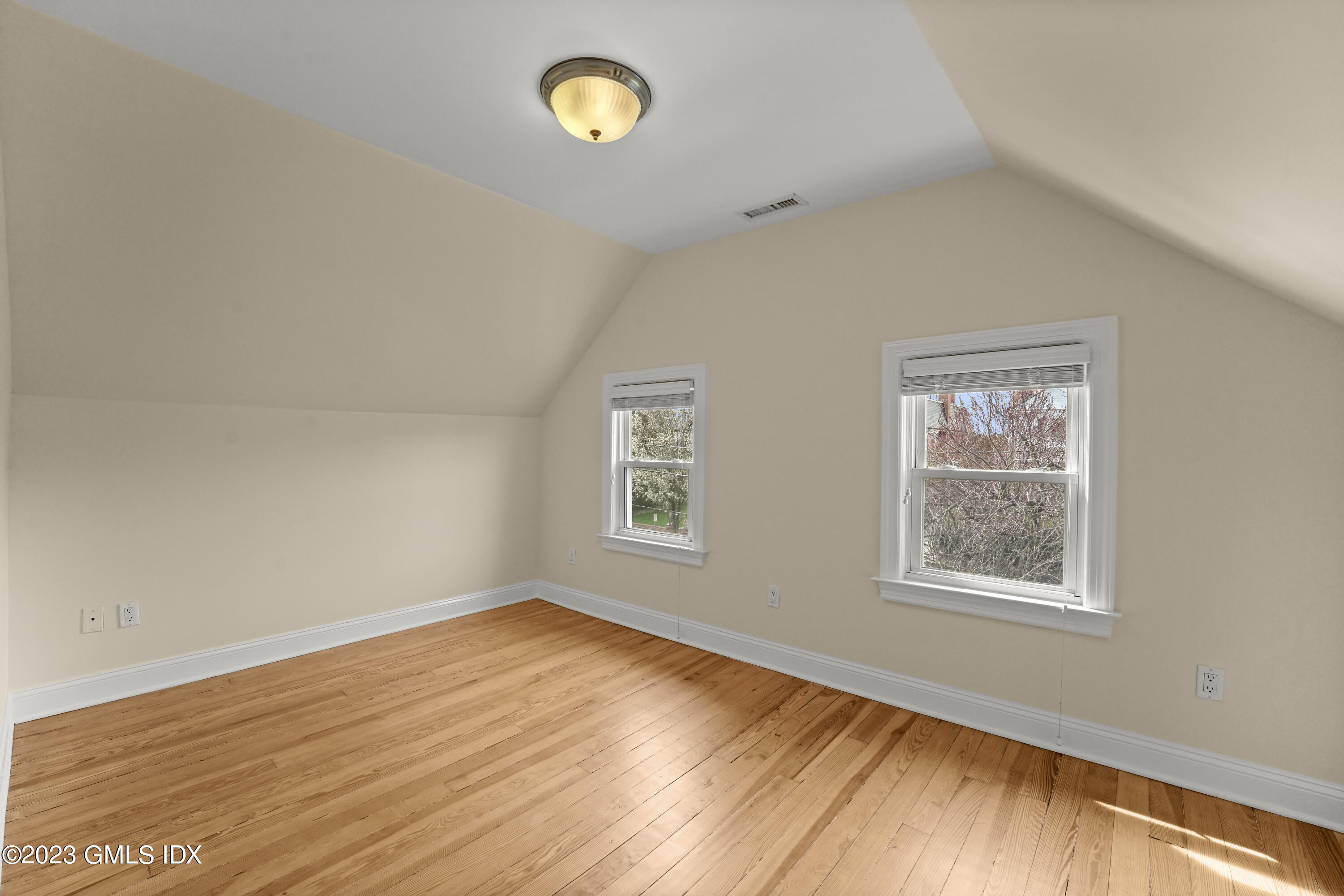 59 Ridge Street, Unit 2 Greenwich, CT 06830 - Photo 21 of 31 a view of an empty room with wooden floor and a window