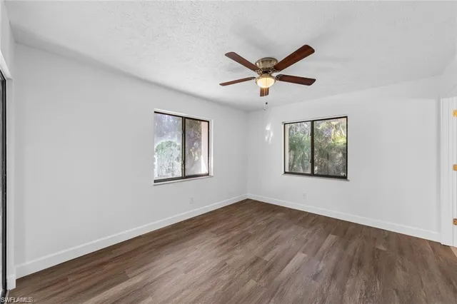 a view of a big room with wooden floor and windows
