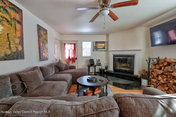 a living room with furniture and a refrigerator