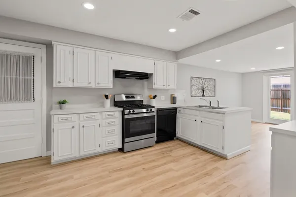 a kitchen with granite countertop a stove top oven sink and cabinets