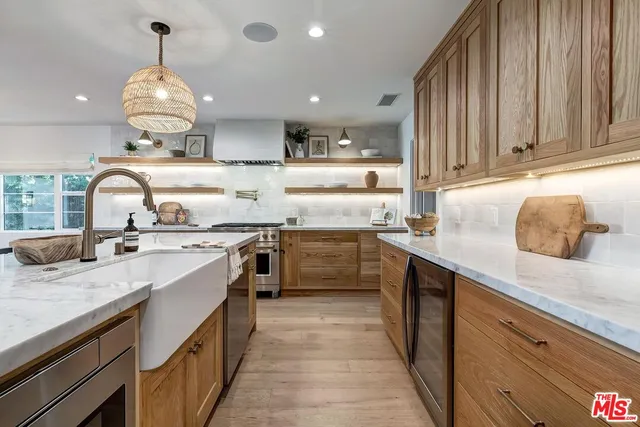 a kitchen with kitchen island granite countertop a sink stainless steel appliances and cabinets