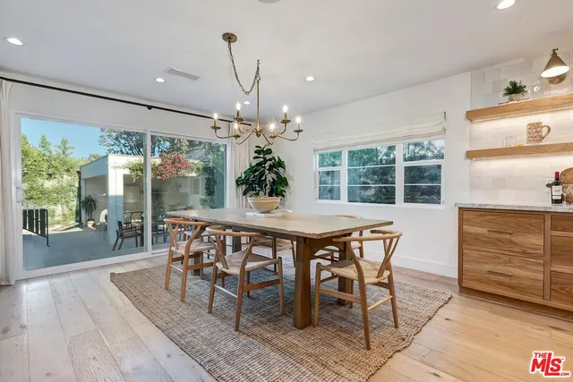 a dining room with furniture a chandelier and wooden floor