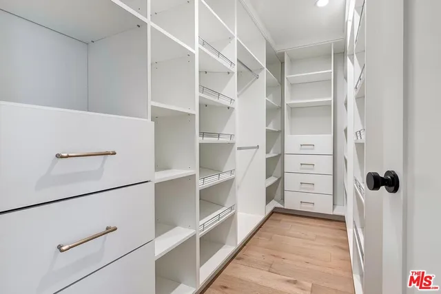 a view of walk in closet with empty racks