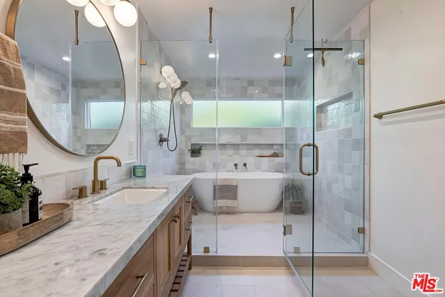 a bathroom with a granite countertop sink mirror and a shower
