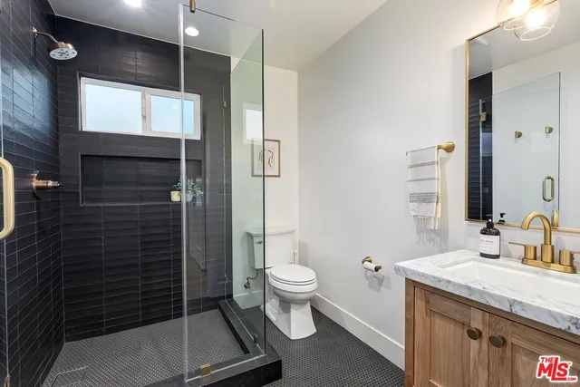 a bathroom with a granite countertop sink toilet and shower