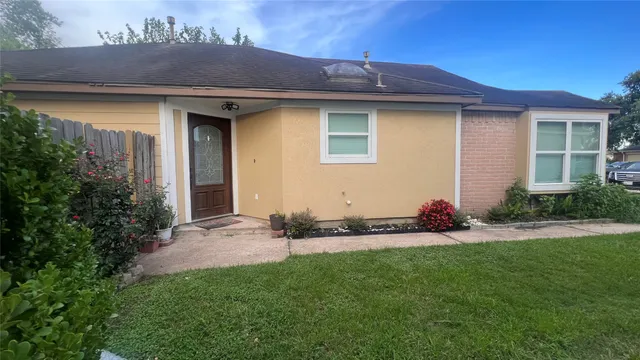 a front view of a house with a garden and yard