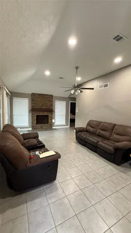 a living room with furniture a flat screen tv and a fireplace