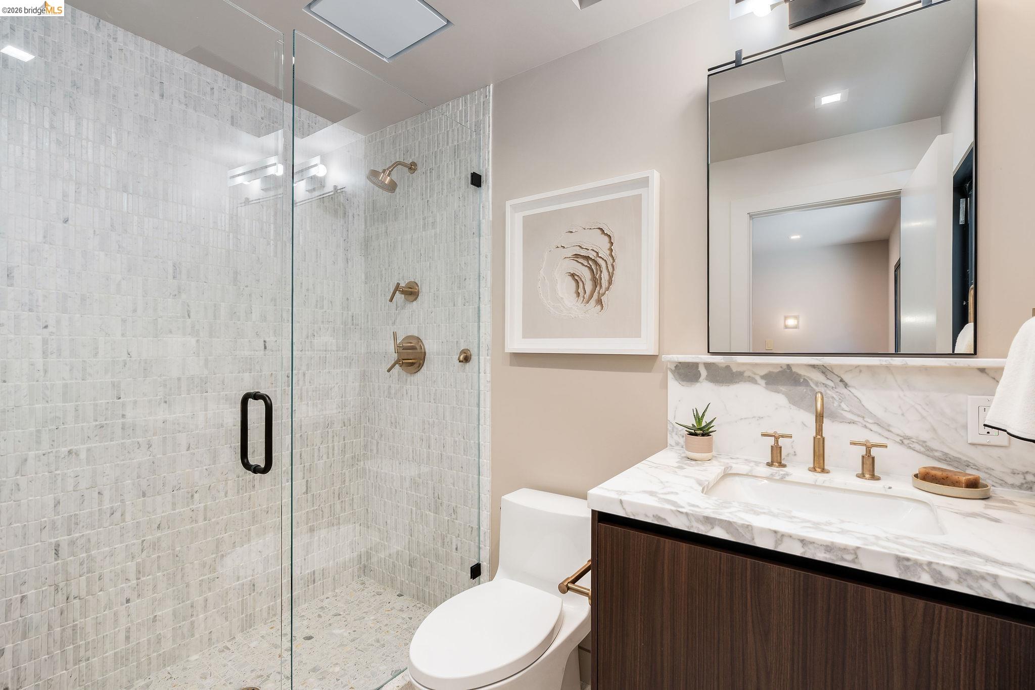 5645 Bacon Road Oakland, CA 94619 - Photo 42 of 94 Modern bathroom featuring a glass-enclosed shower with tile surround and bronze fixtures