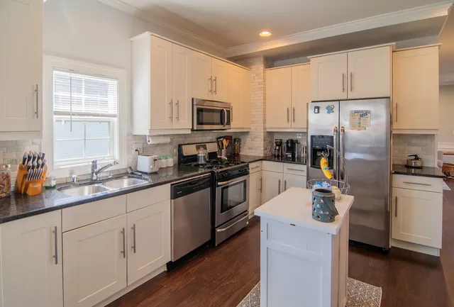 a kitchen with white cabinets sink and stainless steel appliances