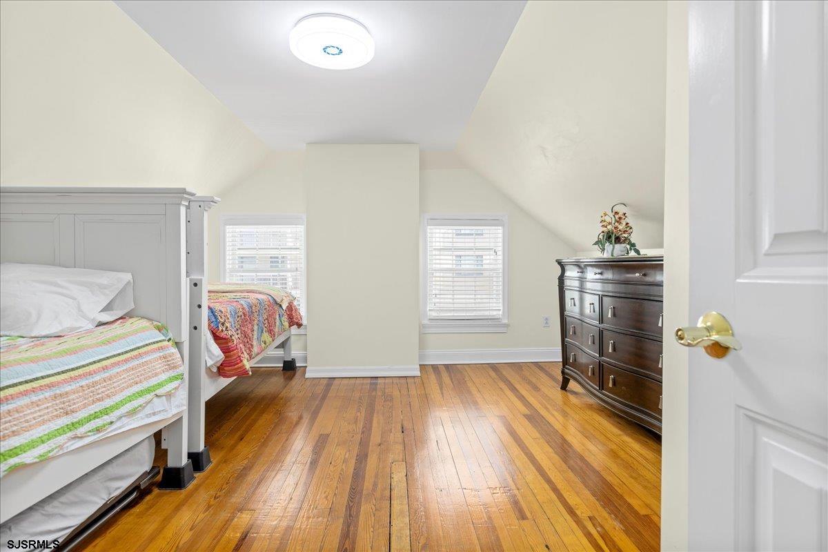 104 South Oakland Avenue, Unit JUNE '26 Ventnor City, NJ 08406 - Photo 34 of 57 a bedroom with a bed and wooden floor
